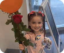 niña con rosa y globo